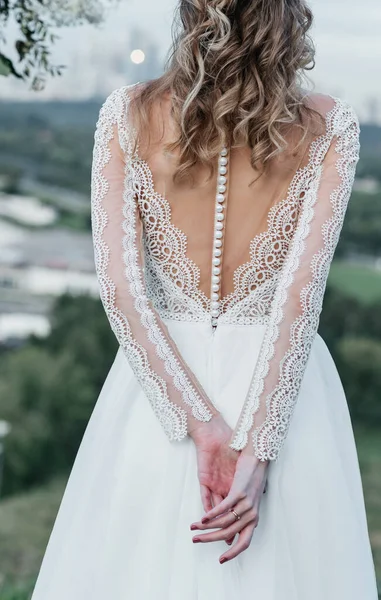 Mano de novias con un elegante anillo de bodas con diamantes de oro blanco en un ramo de sus peonías —  Fotos de Stock