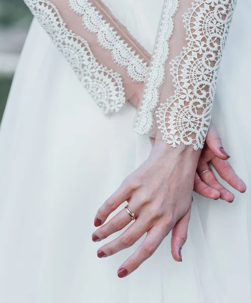 新娘手拿一枚精美的结婚戒指，上面镶嵌着白金钻石和牡丹花束 — 图库照片