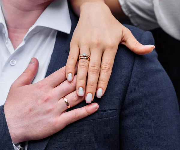 Νέοι άνθρωποι με στριμμένα χέρια στα οποία δαχτυλίδια αρραβώνων γάμου σε λευκό χρυσό με διαμάντια. γαμήλια τελετή — Φωτογραφία Αρχείου
