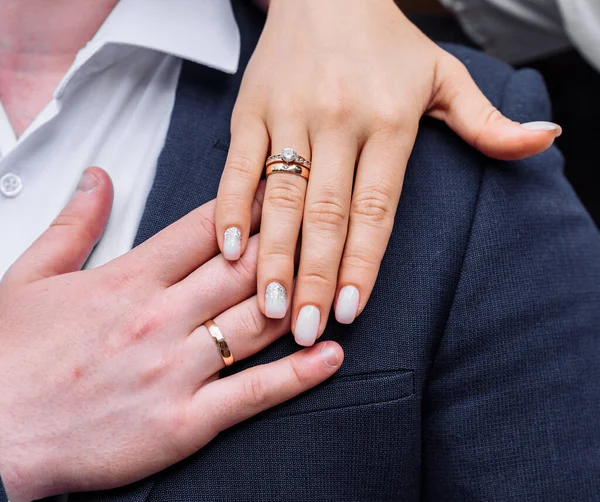 Jóvenes con las manos retorcidas en las que los anillos de compromiso de boda en oro blanco con diamantes. boda ceremonia matrimonio —  Fotos de Stock