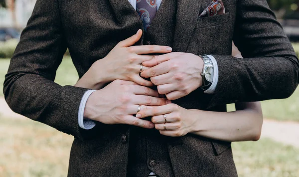 Νύφες χέρι με ένα κομψό δαχτυλίδι γάμου με λευκά χρυσά διαμάντια σε ένα μπουκέτο από παιώνιες τους — Φωτογραφία Αρχείου