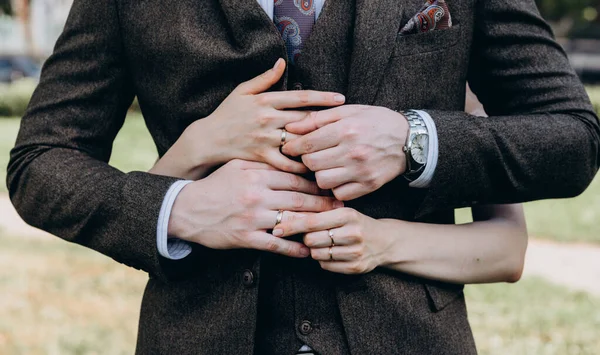 Brides hand with an elegant wedding ring with white gold diamonds on a bouquet of their peonies — Stock Photo, Image