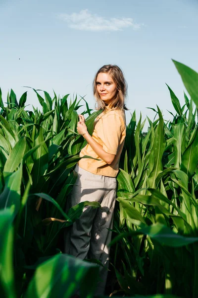 Young woman in a corn field in a yellow t-shirt with a place under the text with short hair — Stock Photo, Image