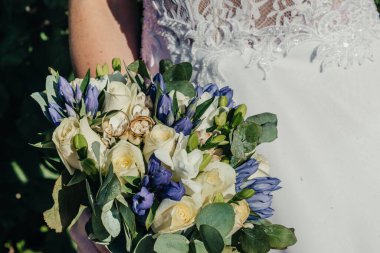 Evlilik yüzükleri takan gençlerin elleri. Düğün günü detayları. Kala çiçekleri. yeni evli eşler damat ve gelin