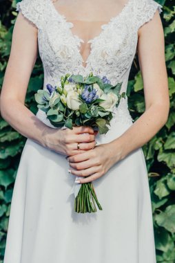 Evlilik yüzükleri takan gençlerin elleri. Düğün günü detayları. Kala çiçekleri. yeni evli eşler damat ve gelin