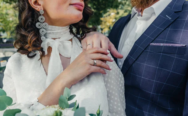 Evlilik yüzükleri takan gençlerin elleri. Düğün günü detayları. Kala çiçekleri. yeni evli eşler damat ve gelin