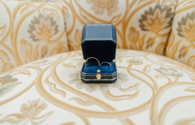 Kutuda beyaz altın alyanslar ve bir buket narin gül ve yeşillik.