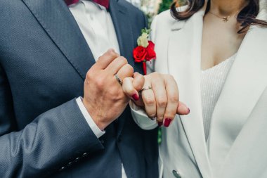 Kutuda beyaz altın alyanslar ve bir buket narin gül ve yeşillik.