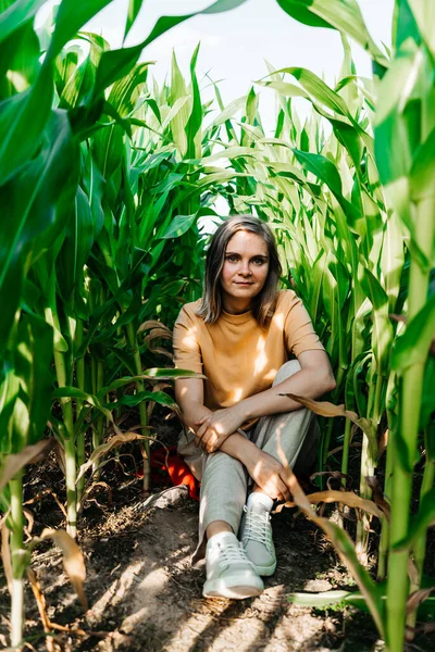 Młoda kobieta na polu kukurydzy w żółtej koszulce z miejscem pod tekstem z krótkimi włosami — Zdjęcie stockowe