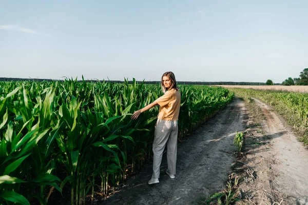Jonge vrouw in een maïsveld in een geel t-shirt met een plaats onder de tekst met kort haar — Stockfoto