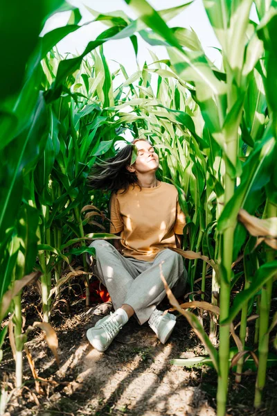 Молодая женщина в кукурузном поле в желтой футболке с местом под текстом с короткими волосами — стоковое фото