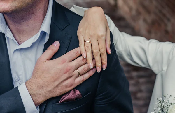 Manos de jóvenes con anillos de boda. detalles del día de la boda. Flores de cala. esposos recién casados novio y novia —  Fotos de Stock