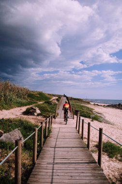 Sporcu motorcu adam okyanus yakınlarındaki açık havada egzersiz yapıyor. Sporcu adam aktif ve sağlıklı bir hayat sürüyor. Gök gürültüsünden önce