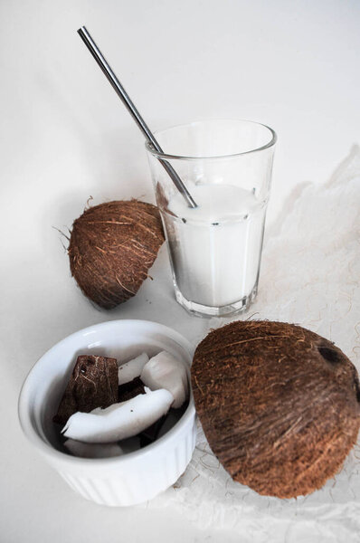 Glass with coconut milk. Chopped coconut. White background. Free space