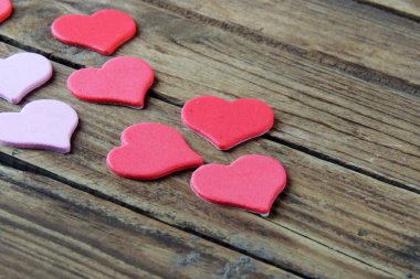 Ahşap beyaz arka plan, kırmızı kalpler, hediyeler ve mumlar. Sevgililer Günü konsepti.