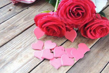 Ahşap beyaz arka plan, kırmızı kalpler, hediyeler ve mumlar. Sevgililer Günü konsepti.