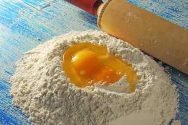 Pişirme için-malzemeler un, tahta kaşık, oklava, yumurta. Üstten Görünüm, kopya alanı.