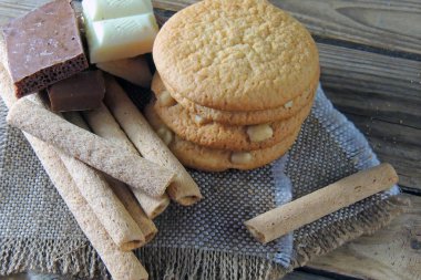 Ahşap üzerine çift çikolatalı kurabiye. kurabiye ve tatlı tüpler