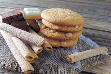 Ahşap üzerine çift çikolatalı kurabiye. kurabiye ve tatlı tüpler