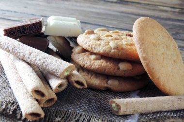 Ahşap üzerine çift çikolatalı kurabiye. kurabiye ve tatlı tüpler