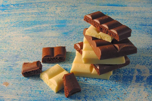 Witte Zwarte Chocolade Een Blauwe Achtergrond — Stockfoto