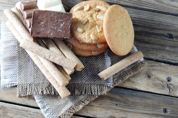 Ahşap üzerine çift çikolatalı kurabiye. kurabiye ve tatlı tüpler