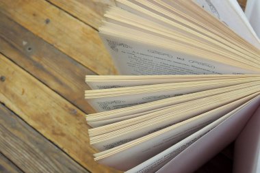 Vadideki zambak ve beyaz masada eski kitaplar. Bahar mevsiminin sembolü. Romantik ilkbahar, ilham verici bir hava..