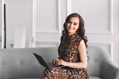 Evde dizüstü bilgisayar kullanan genç bir kadın. Bir öğrenci bilgisayarda çalışır. Serbest, TEKNOLOJİ, online alışveriş, ev işleri, online eğitim. Uzaklık öğrenimi.