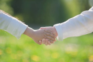 Beyaz elbiseli küçük kızlar parkta el ele tutuşuyorlar. Arkadaşlık..