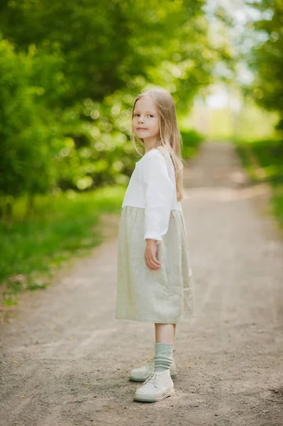 Portrait of a little girl in white in a Park in summer.