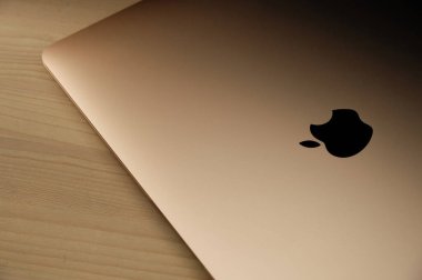 Recanati, Macerata, Italia - 11 Haziran 2020: Gıcır gıcır yeni altın macbook havası (2020), ince ve hafif, ahşap bir masada alüminyum alaşımlı alüminyum bir defter, Apple logosu siyah, yakın plan.