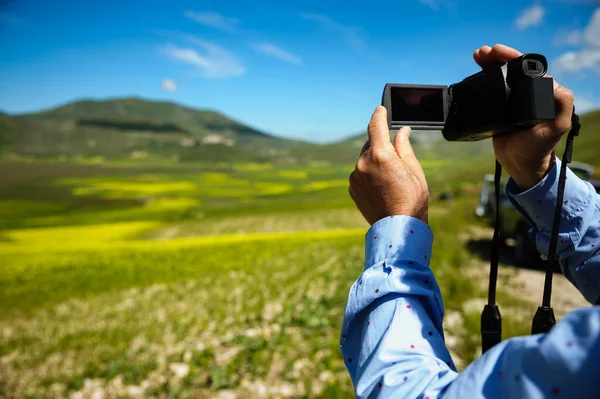 Man taking a video of the panorama towards Castelluccio di Norcia.