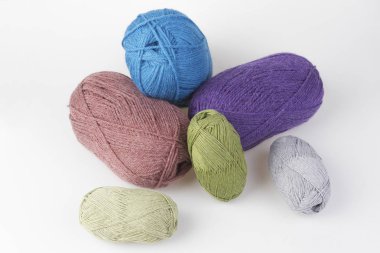 Yün elleri ile örgü için rahim. Küçük ve büyük beyaz arka planda dağınık