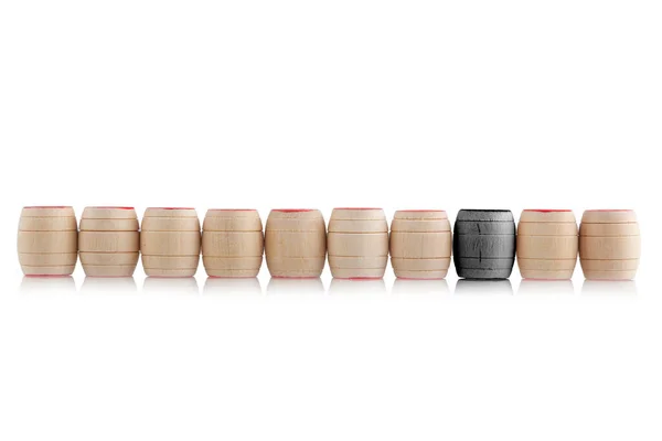 Pequeños barriles de madera de pie en una fila, uno resaltado en negro . — Foto de Stock
