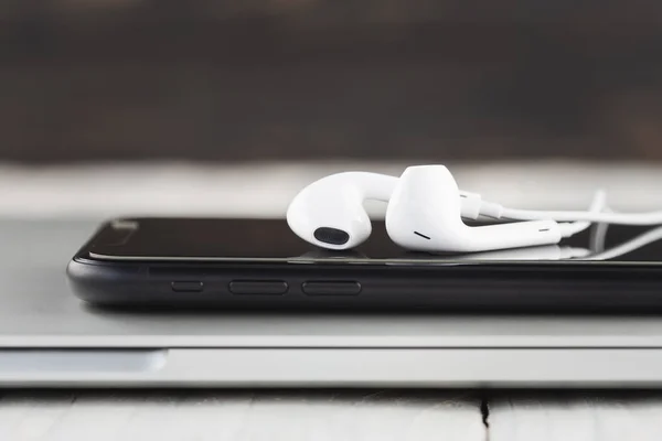 Close-up phone and headphone stack on laptop computer front view — Stock Photo, Image