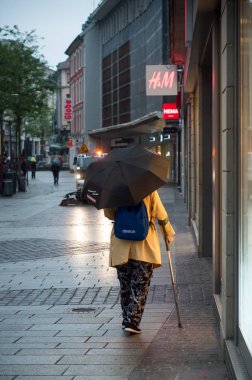 Mulhouse - Fransa - 16 Mayıs 2018 - yağmurlu gün sabah şemsiye ile sokakta yürürken kadın