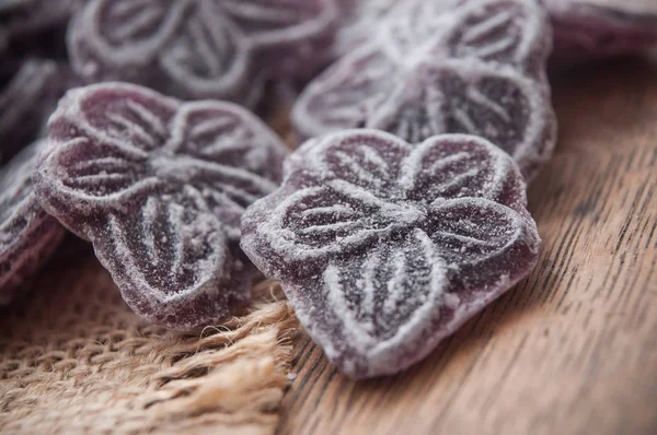 Traditional Purple Candies Shaped Flower Hessian Wooden Background — Stock Photo, Image