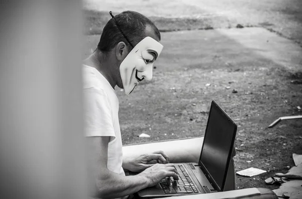 フランス 2018 男の肖像ヴェンデッタ マスクとヴィンテージ アームチェアに廃工場で Coumputer このマスクは匿名オンライン政治的ハッカー グループの有名なシンボル — ストック写真