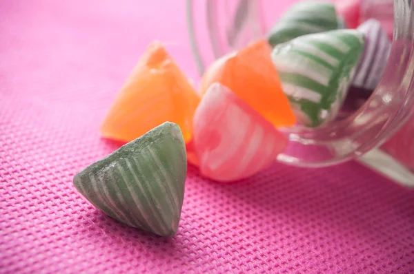 Closeup Colorful Traditional Candies Falling Glass Container Pink Background — Stock Photo, Image