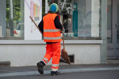 Kadın belediye çalışanı kürek ve süpürge ile el yürüme