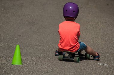 paten kurulu kask ile oturan çocuk portresi