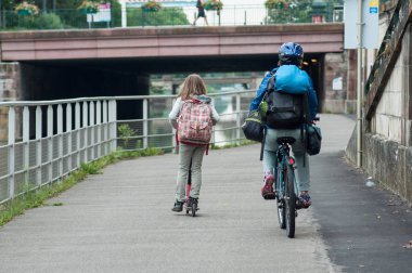 Mulhouse - Fransa - 11 Haziran 2018 - scooter kız ve sırt çantası sınır su ile bisiklet kask ile haddeleme kadın