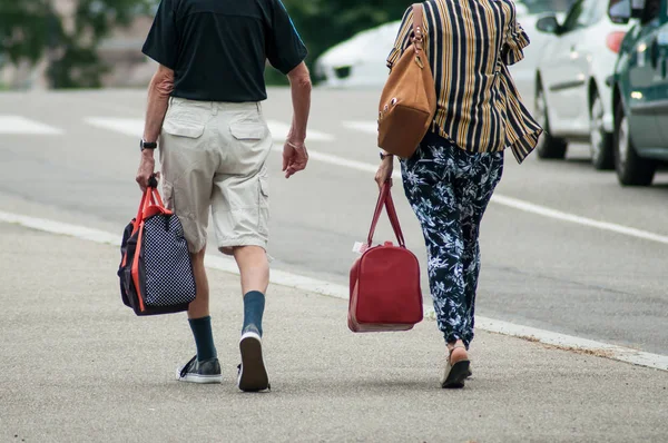 closeup of couple walking with bag near train station back view