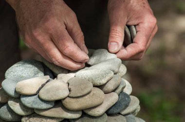 yeşil ahşap masa üzerinde taşlar bakiyesini adamın elini closeup arka plan bulanık 