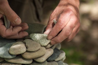 yeşil ahşap masa üzerinde taşlar bakiyesini adamın elini closeup arka plan bulanık 