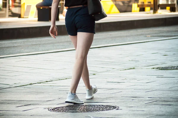 closeup of girl with short walking in front of the train station