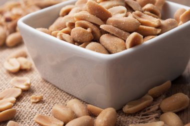 ahşap arka plan üzerinde bir porselen kase tuzlu fıstık closeup