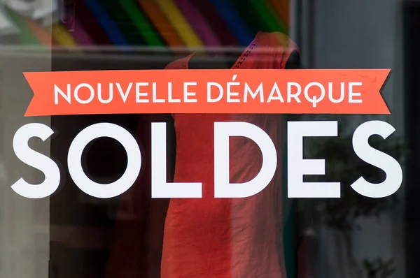 夏服の背景にフランスのファッション店のショールームのウィンドウで記号 Soldes ヌーヴェル Demarque はフランス語で 売り上げ高 新しい記法 の食品を割引します — ストック写真