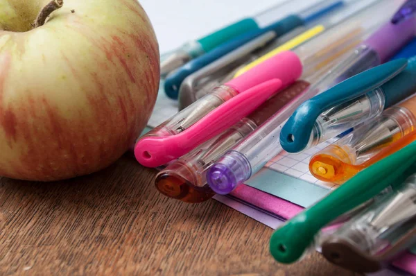 Zbliżenie Kolorowe Długopisy Apple Książki Pamiętać Podłoże Drewniane Biurko — Zdjęcie stockowe