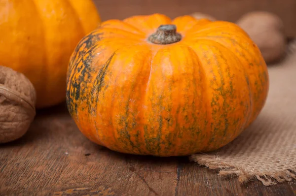 küçük kabak ve ceviz ahşap arka plan üzerinde closeup